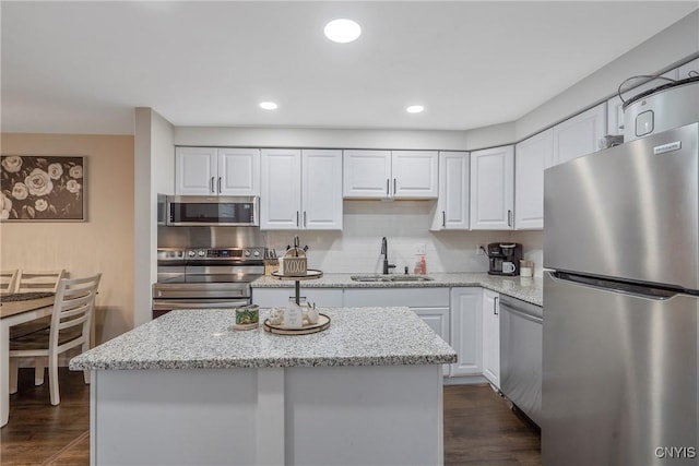 8433 Bubbling Springs Dr, Clay, NY 13027 - kitchen with stainless steel appliances, white cabinets, light stone countertops, dark wood-style flooring, and recessed lighting