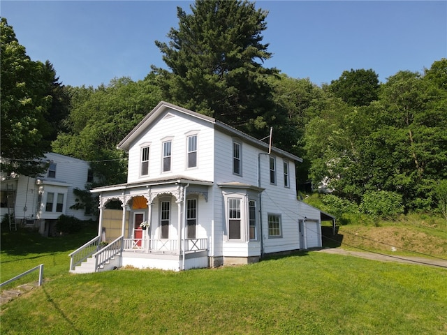 2 2nd St, Eldred, PA 16731 - view of front of house featuring covered porch, driveway, a front yard, and a wooded view