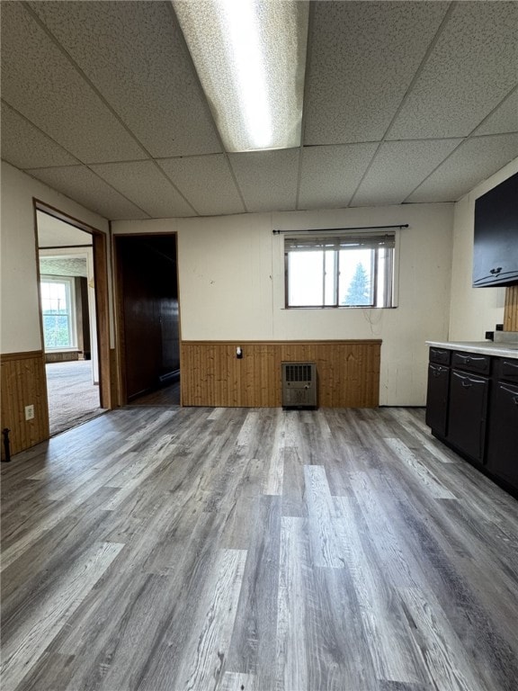 2 2nd St, Eldred, PA 16731 - unfurnished living room featuring a wainscoted wall, a drop ceiling, wood finished floors, healthy amount of natural light, and wood walls