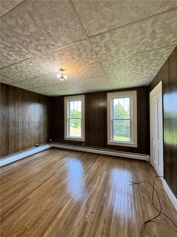 2 2nd St, Eldred, PA 16731 - spare room with healthy amount of natural light, wood finished floors, wooden walls, and baseboard heating