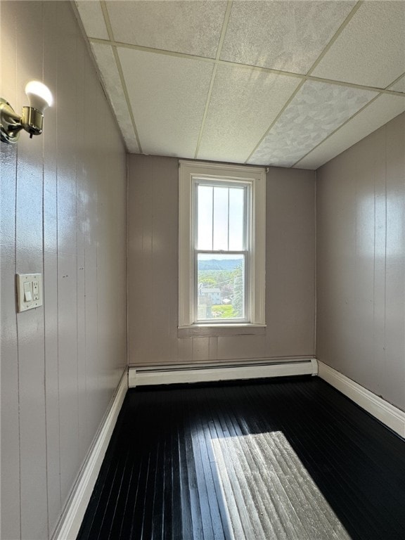 2 2nd St, Eldred, PA 16731 - unfurnished room featuring wood-type flooring, a paneled ceiling, and a baseboard heating unit