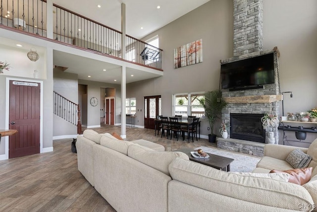 3785 Ransom Rd, Pompey, NY 13078 - living room featuring a high ceiling, a fireplace, wood finished floors, stairway, and recessed lighting