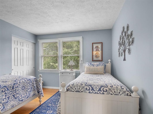 27 Black Spruce Ct, Greece, NY 14616 - bedroom featuring wood finished floors, a textured ceiling, and a closet