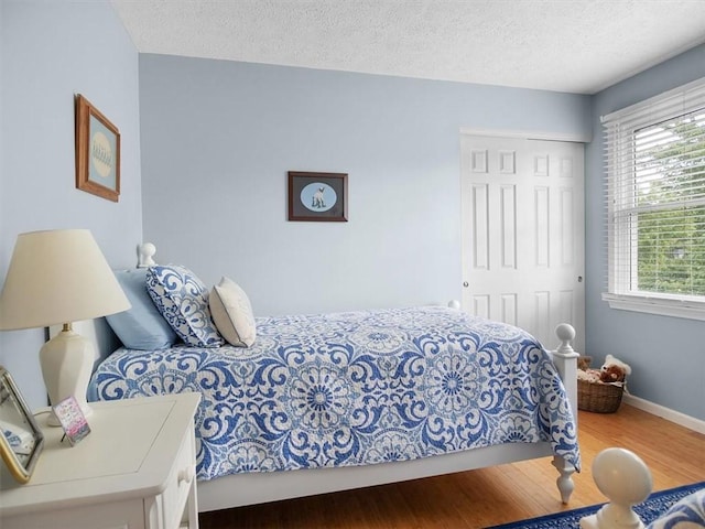 27 Black Spruce Ct, Greece, NY 14616 - bedroom with wood finished floors, a closet, and a textured ceiling