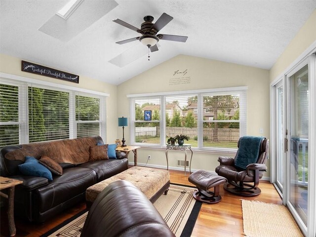 27 Black Spruce Ct, Greece, NY 14616 - living area with a skylight, wood finished floors, vaulted ceiling, a textured ceiling, and a ceiling fan