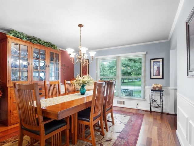27 Black Spruce Ct, Greece, NY 14616 - dining room with a chandelier, ornamental molding, wood finished floors, and wainscoting