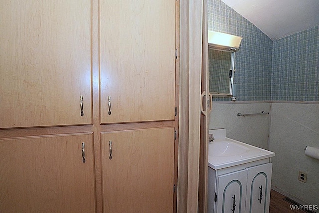 3840 Coomer Rd, Newfane, NY 14108 - bathroom featuring lofted ceiling, vanity, and wood finished floors