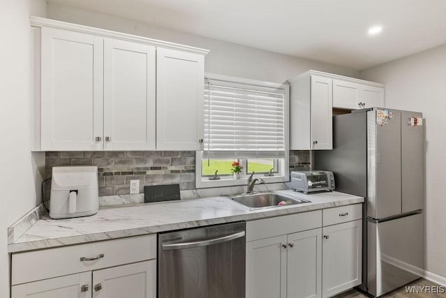503 Kohl St, North Tonawanda, NY 14120 - kitchen with appliances with stainless steel finishes, white cabinets, tasteful backsplash, recessed lighting, and light stone countertops