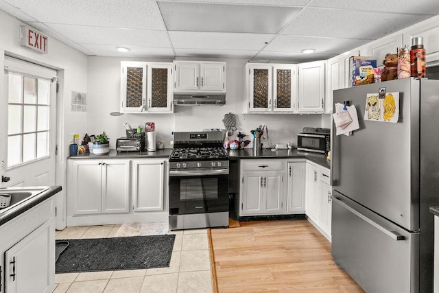 485 Spring Valley Rd, Delhi, NY 13753 - kitchen with appliances with stainless steel finishes, under cabinet range hood, a drop ceiling, light tile patterned floors, and glass insert cabinets