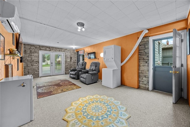 703 N Perry St, Dix, NY 14891 - carpeted living room with a wall mounted air conditioner, estacked washer and dryer, and french doors
