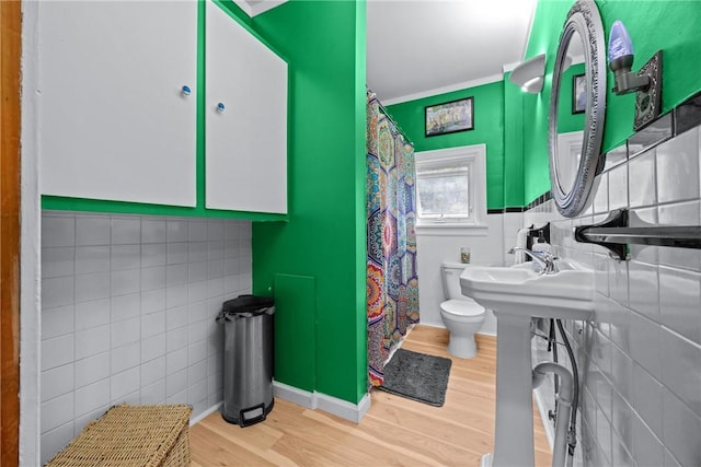 703 N Perry St, Dix, NY 14891 - bathroom with tile walls, wood finished floors, crown molding, and curtained shower