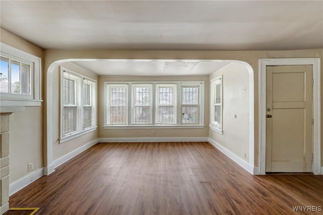 210 Carl St, Buffalo, NY 14215 - empty room featuring arched walkways, healthy amount of natural light, and wood finished floors