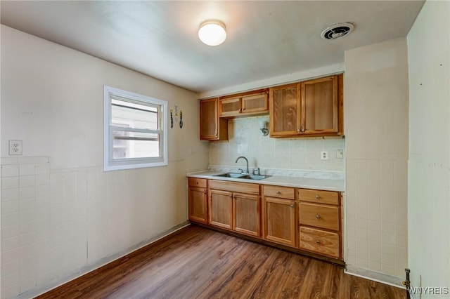 210 Carl St, Buffalo, NY 14215 - kitchen with dark wood-style flooring, light countertops, brown cabinetry, and a wainscoted wall