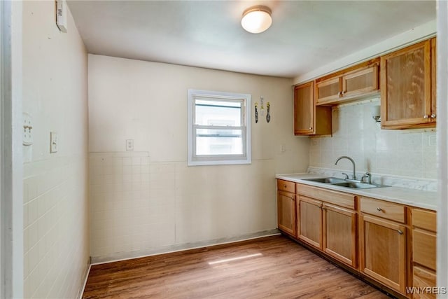 210 Carl St, Buffalo, NY 14215 - kitchen featuring light countertops, light wood-style flooring, brown cabinetry, and tasteful backsplash