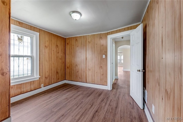 210 Carl St, Buffalo, NY 14215 - empty room with arched walkways, plenty of natural light, wood finished floors, wooden walls, and ornamental molding