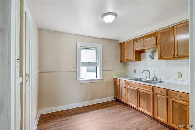 210 Carl St, Buffalo, NY 14215 - kitchen with light wood finished floors, light countertops, backsplash, and brown cabinetry