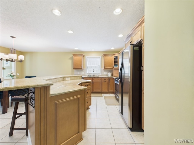 4166 Tisbury Ln, Hamburg, NY 14075 - kitchen with appliances with stainless steel finishes, a kitchen breakfast bar, light tile patterned floors, light stone counters, and pendant lighting