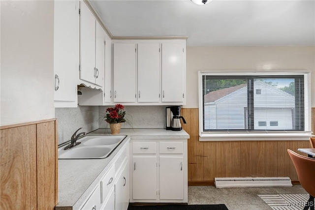 357 Hastings Ave, Buffalo, NY 14215 - kitchen with baseboard heating, white cabinetry, light countertops, and wood walls