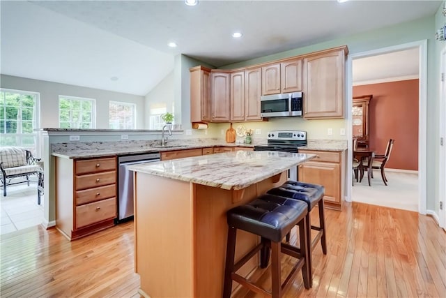 74 Chadwick Mnr, Perinton, NY 14450 - kitchen featuring appliances with stainless steel finishes, healthy amount of natural light, a breakfast bar area, light stone counters, and recessed lighting