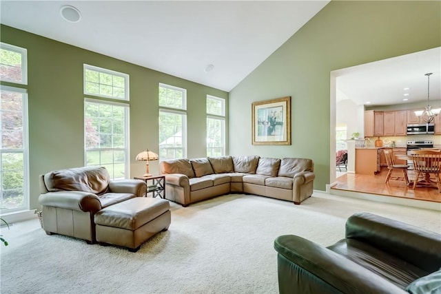 74 Chadwick Mnr, Perinton, NY 14450 - living area featuring light colored carpet, plenty of natural light, a chandelier, and high vaulted ceiling