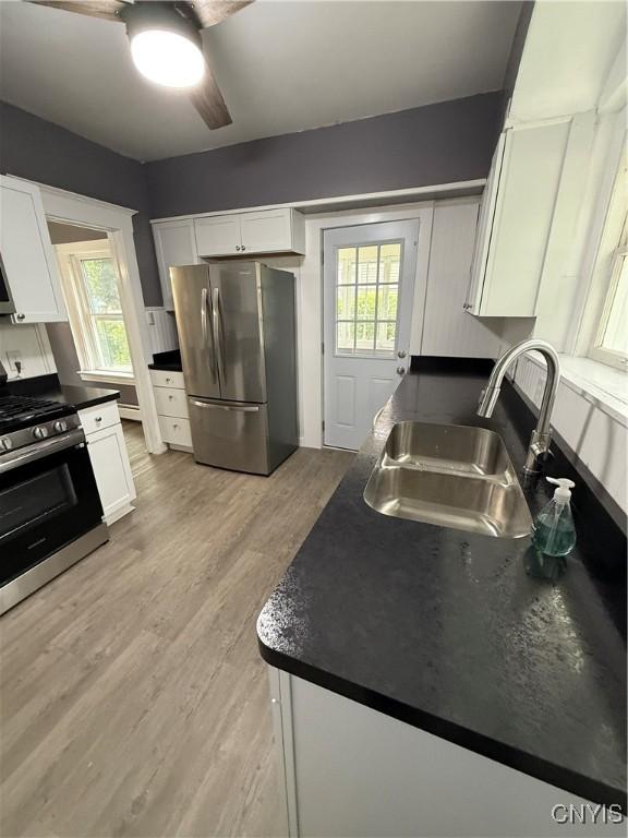 37 Peacock St, Auburn, NY 13021 - kitchen with stainless steel appliances, dark countertops, white cabinetry, and ceiling fan