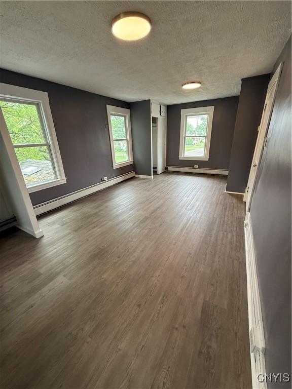 37 Peacock St, Auburn, NY 13021 - unfurnished room featuring a textured ceiling, a baseboard radiator, and dark wood-style flooring