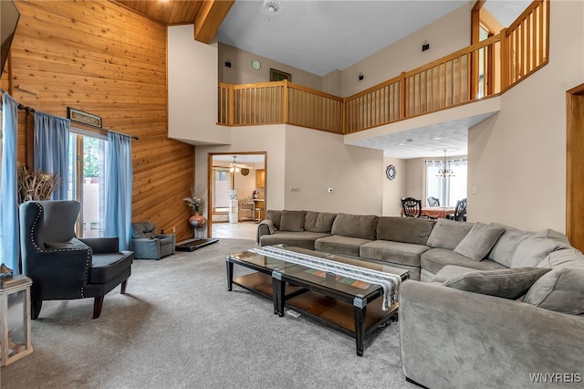 2160 Robert Dr, Niagara, NY 14304 - living room with a towering ceiling, wooden walls, carpet, and a chandelier
