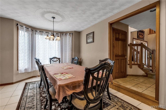 2160 Robert Dr, Niagara, NY 14304 - dining space featuring a chandelier, light tile patterned floors, and stairway