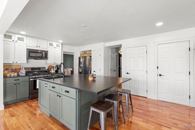 5418 Quamby Rd, Clay, NY 13041 - kitchen with appliances with stainless steel finishes, dark countertops, recessed lighting, a kitchen breakfast bar, and white cabinetry
