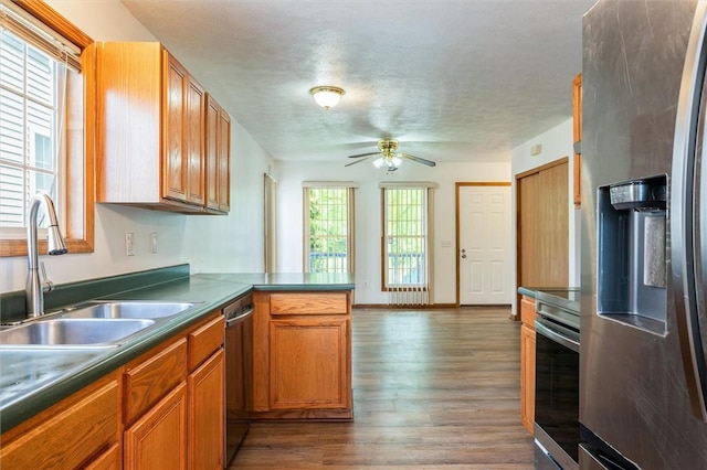 282 Troup St, Rochester, NY 14608 - kitchen with stainless steel appliances, wood finished floors, a peninsula, a ceiling fan, and dark countertops