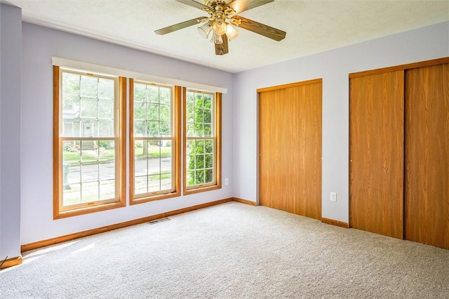 282 Troup St, Rochester, NY 14608 - unfurnished bedroom featuring carpet flooring, two closets, and ceiling fan