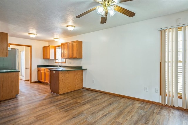 282 Troup St, Rochester, NY 14608 - kitchen with dark countertops, wood finished floors, brown cabinets, and a ceiling fan