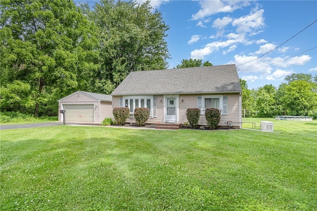 2622 Nichols St, Ogden, NY 14559 - cape cod house featuring an outbuilding, a garage, a front yard, and a shingled roof