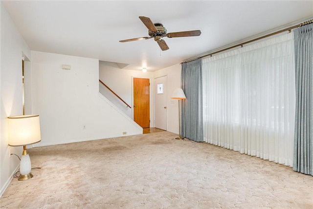 2622 Nichols St, Ogden, NY 14559 - unfurnished living room with stairway, ceiling fan, and carpet
