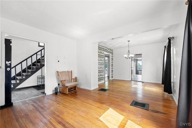 119 Kenneth Ave, Onondaga, NY 13120 - unfurnished living room featuring wood-type flooring, a chandelier, and stairway
