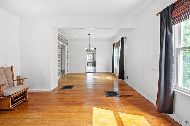 119 Kenneth Ave, Onondaga, NY 13120 - unfurnished dining area with a chandelier, plenty of natural light, and light wood-style floors