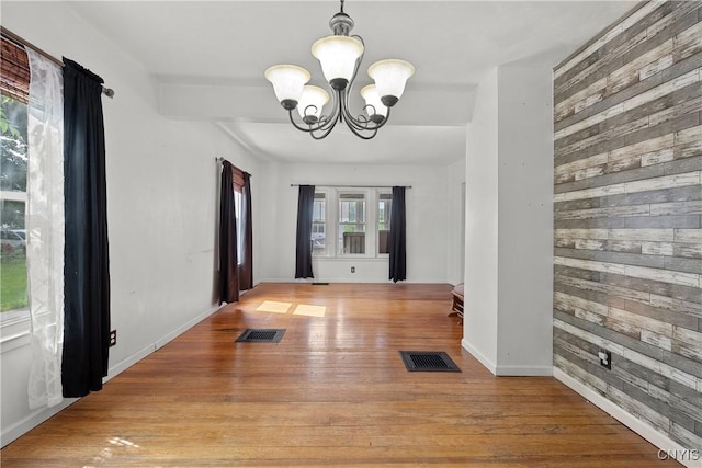 119 Kenneth Ave, Onondaga, NY 13120 - unfurnished dining area featuring wood walls, a chandelier, and light wood-style floors