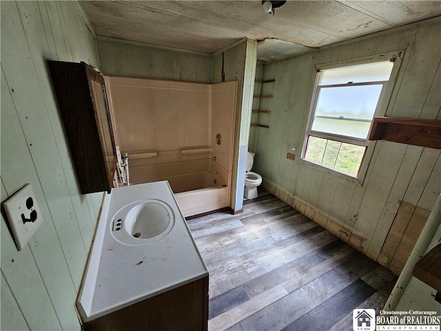 20 N Main St, Bolivar, NY 14715 - bathroom featuring wood finished floors, wood walls, vanity, and tub / shower combination