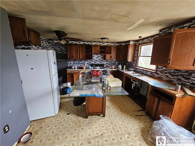 20 N Main St, Bolivar, NY 14715 - kitchen with freestanding refrigerator, backsplash, a ceiling fan, and a center island
