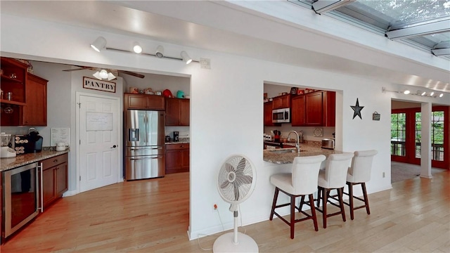 11 Overbrook Rd, Erwin, NY 14870 - kitchen with appliances with stainless steel finishes, light wood-style flooring, a peninsula, a kitchen bar, and beverage cooler
