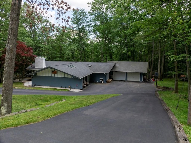 11 Overbrook Rd, Erwin, NY 14870 - view of front of home with an attached garage, roof with shingles, asphalt driveway, a chimney, and board and batten siding