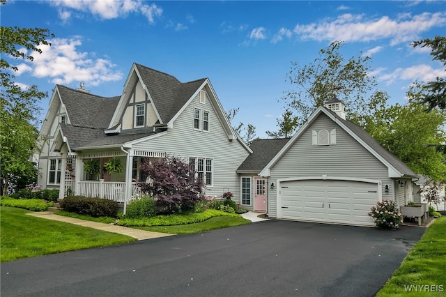 2846 Amsdell Rd, Hamburg, NY 14075 - view of front of house featuring a shingled roof, covered porch, asphalt driveway, a front lawn, and an attached garage
