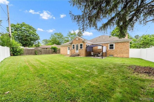 34 Wainwright Rd, Cheektowaga, NY 14215 - back of house featuring entry steps, brick siding, a fenced backyard, and a patio area