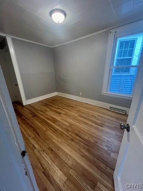 232 Hall Ave, Syracuse, NY 13205 - unfurnished bedroom featuring wood finished floors and crown molding