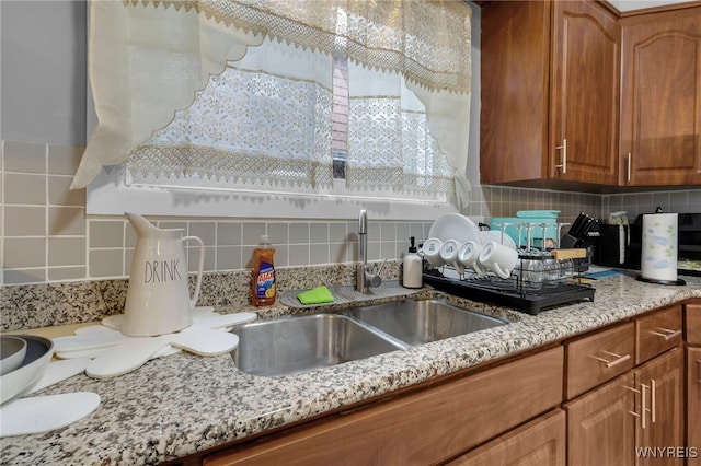 549 15th St, Niagara Falls, NY 14301 - kitchen featuring backsplash, brown cabinets, and light stone counters