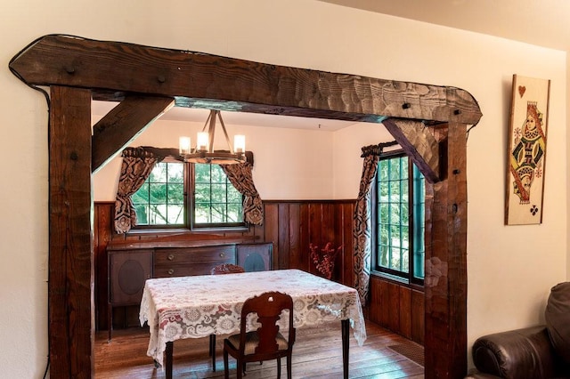 320 Glen Ave, Elmira, NY 14905 - dining area with hardwood / wood-style floors, a chandelier, wooden walls, and wainscoting