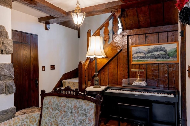 320 Glen Ave, Elmira, NY 14905 - living area featuring beam ceiling, stairs, a chandelier, and wooden walls
