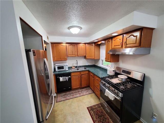 56 Canasta Rd, Greece, NY 14615 - kitchen featuring appliances with stainless steel finishes, under cabinet range hood, brown cabinetry, a textured ceiling, and dark countertops