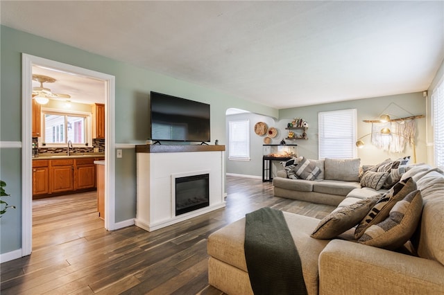 387 Brandon Rd, Irondequoit, NY 14622 - living room with arched walkways, a glass covered fireplace, and dark wood-type flooring