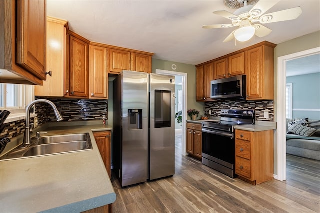 387 Brandon Rd, Irondequoit, NY 14622 - kitchen featuring appliances with stainless steel finishes, a ceiling fan, decorative backsplash, and light wood-style flooring